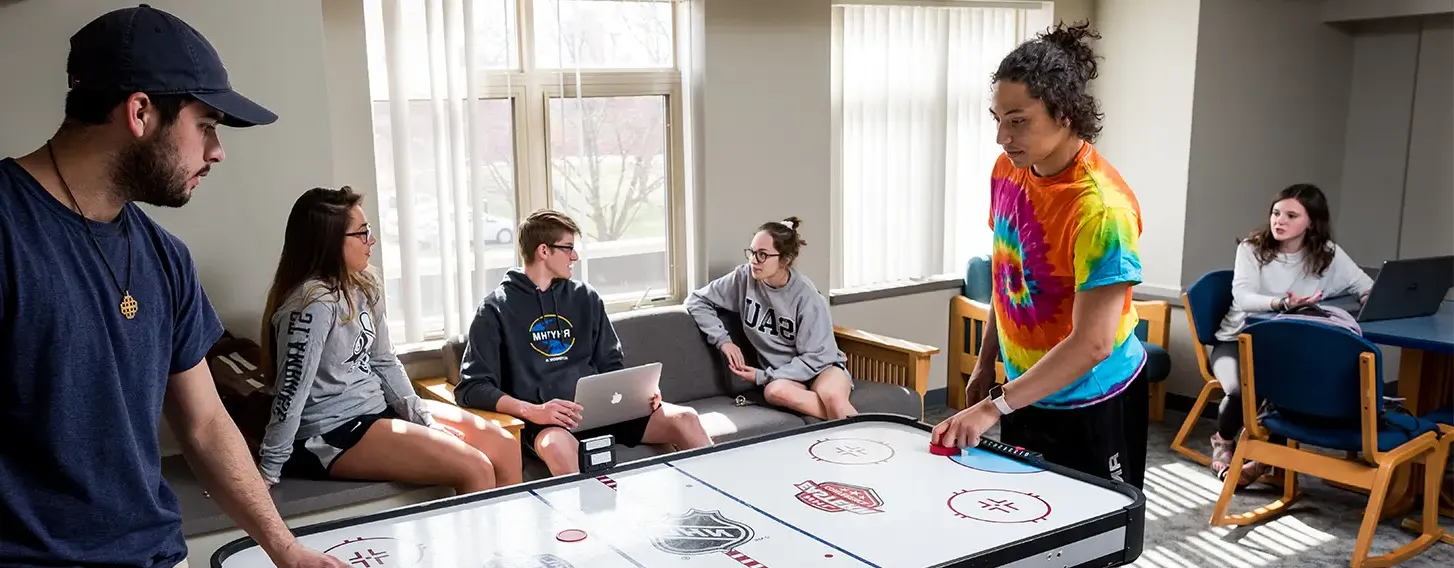 students talking with each other in a common space and playing a game